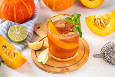 Thanksgiving Margarita, Sweet Pumpkin Shrubs cocktail, alcohol tasty autumn drink on white background with slices pumpkins, copy space clipart