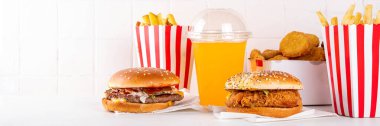 Fast food servis menüsünde çeşitli hamburgerler, cheeseburger, nugget, patates kızartması, gazlı içecek. Ivır zıvır sağlıksız fast food, düşük besinli Ultra işlenmiş gıda, yüksek kalori değeri