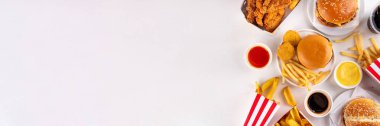 Fast food servis menüsünde çeşitli hamburgerler, cheeseburger, nugget, patates kızartması, gazlı içecek. Ivır zıvır sağlıksız fast food, düşük besinli Ultra işlenmiş gıda, yüksek kalori değeri
