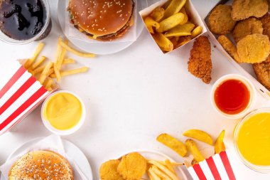 Fast food servis menüsünde çeşitli hamburgerler, cheeseburger, nugget, patates kızartması, gazlı içecek. Ivır zıvır sağlıksız fast food, düşük besinli Ultra işlenmiş gıda, yüksek kalori değeri