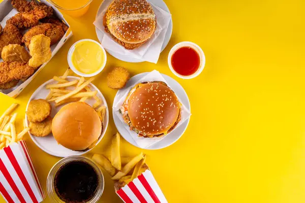 stock image Fast food delivery menu background with various burgers, cheeseburger, nuggets, french fries, fizzy soda drinks. Junk unhealthy fast food, Ultra processed food with low nutrition, high calories value