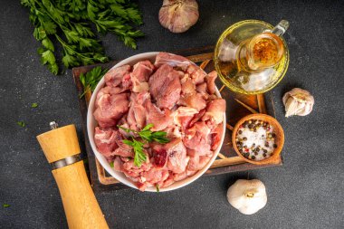 Veal, beef red meat raw chopped goulash, with herbs, condiment, olive oil and spices, cooking dinner background copy space clipart