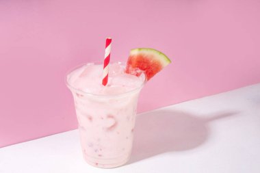 Lezzetli karpuzlu milkshake veya kremalı buzlu içecek karışımı, plastik bardakta karpuz dilimi, kopyalama alanı