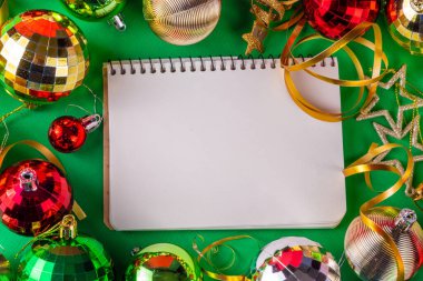 Parlak yeşil yeni yıl arkaplanı, kırmızı, yeşil, altın kostüm topları, flamalar ve süslemeler, üst görünüm fotokopi alanı. Noel ve Yeni Yıl tebrik kartı düzleştirildi