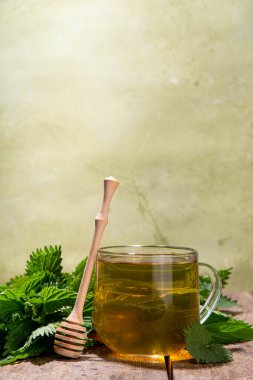 Nettle Tea sıcak bitkisi şeffaf cam bardakta içecek. Organik doğal bitkisel çay kafeinsiz, organik çiğ ısırgan otu yapraklarıyla yapılır. Alternatif bitkisel ilaç. Isırgan otu, urtica.