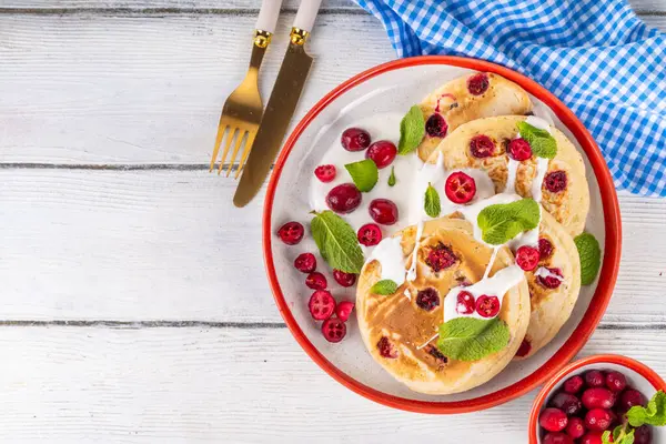 Kış kahvaltısı ya da brunch için yaban mersinli krep. Noel kutlaması, yeni yıl kahvaltısı vanilyalı kremalı tatlı ve taze kızılcık, kopyalama alanı.