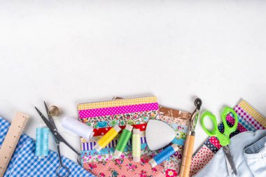 Dikiş dikme, dikiş ve giysi onarımı, arka plan, koleksiyon defteri, yorgan dikme. Renkli kumaş, makas, cetvel, dikiş araçları, iğneler, iplikler beyaz masa arkaplanındaki üst görünüm kopyalama alanı