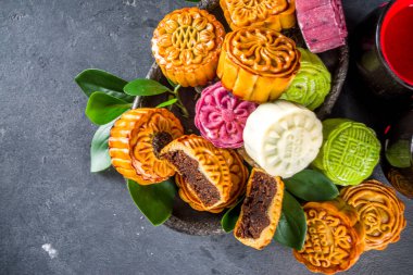 Traditional Chinese sweet dessert. Homemade Chinese snow skin and baked mooncakes, Chinese Mid-Autumn Festival food, colorful rice cakes, flatlay top view copy space clipart