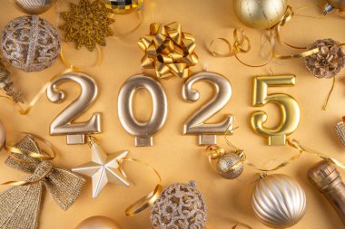 Mutlu Noeller ve mutlu yıllar 2025 altın takı, noel ağacı topları ve süslemeleri, hediye yayı, yılan, 2025 altın mum numarası, düz görünüm fotokopi alanı