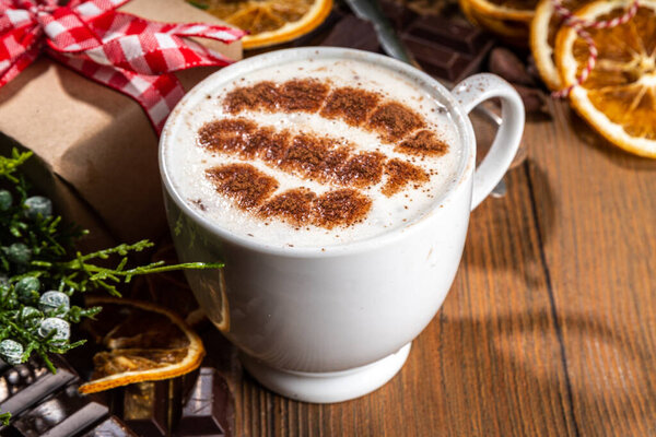 Капучино, кофе с горячим шоколадом латте с рождественским рисунком на теплом деревянном фоне, Рождественская зимняя уютная чашка с горячим шоколадным напитком в руках женщины, вид сверху копировальное пространство 