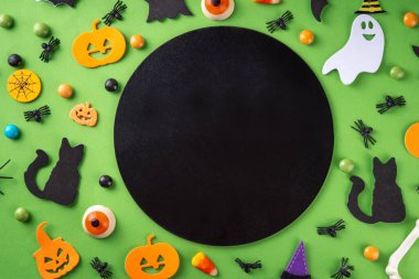 Halloween bright holiday background with traditional holiday symbols - pumpkins, ghost, black cat, witch hat, spiders. Halloween invitation, greeting card background top view copy space clipart