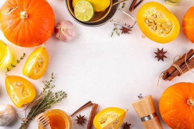 Balkabağı pişirme arka planı dilimlenmiş balkabağı yarımları ya da tereyağlı kabak, çiğ otlar. Beyaz arka planda kesim tahtası, bitki ve bal içeren baharatlar. Şükran Günü yemeği mevsimlik yemek