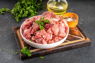 Veal, beef red meat raw chopped goulash, with herbs, condiment, olive oil and spices, cooking dinner background copy space clipart