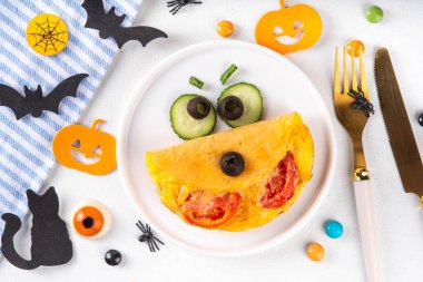 Cadılar Bayramı kahvaltısı omleti tatlı canavar şeklinde ve dekore edilmiş taze sebzeler, komik çocuklar Cadılar Bayramı yemeği fikri