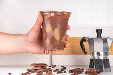 Viral Çikolatalı Latte içeceği. Buzlu latte ve mocachino ile doldurulmuş çikolatalı plastik bardak.