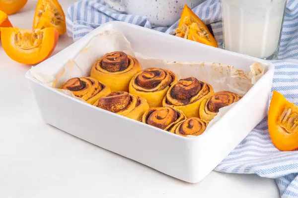 stock image Homemade sweet autumn pumpkin cinnamon swirled bun rolls, pumpkin cinnabons with pecan nuts, cinnamon and creamy cheese icing