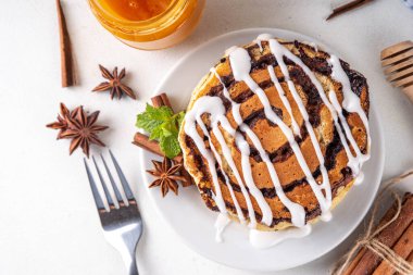 Ev yapımı tarçınlı krep yığını, tarçınlı krep sarmalı tarçın ve krem peynirli jöle, beyaz mutfak masası, fotokopi masası.