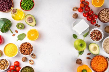 Portföy diyeti, fındık, sebze proteini, bitki sterolleri, yapışkan lif, fasulye, baklagiller, taze sebzeler ve beyaz arka plandaki meyveler dahil olmak üzere dengeli kolesterol vejetaryen gıdalar.