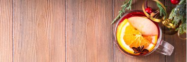 Tatlı elma, portakal, bal, tarçın ve anason yıldızlı cam bardak, ahşap masa üzerinde Noel süsü, tatil içkisi. Sıcak baharatlı amber çayı, alkolsüz sıcak içecek.