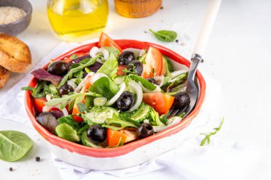 Domatesli taze organik salata, salatalık, zeytin ve yeşillik. Sağlıklı diyet vegan yemekleri, Akdeniz sebze salatası beyaz mutfak masasında fotokopi alanı