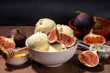 Lezzetli incirli dondurma, aromatik ve kremalı meyveli tatlı, baharatlı tatlı, porsiyonlu kâse, ahşap kaplama, bütün ve ince incir dilimleri, kopyalama alanı.