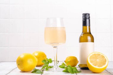 Dilimlenmiş limon ve nane aromalı nefis narenciye şarabıyla limon şarabı ve şişe. 