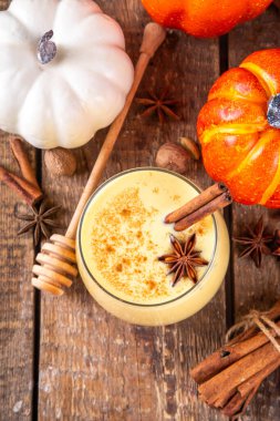 Sonbahar içkisi, balkabağı baharatlı eggnog kokteyli, bal, tarçın çubukları ve anason yıldızları, lezzetli tatlı mevsimi içeceği 