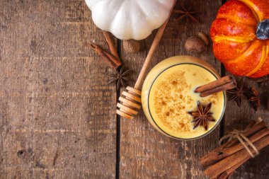 Sonbahar içkisi, balkabağı baharatlı eggnog kokteyli, bal, tarçın çubukları ve anason yıldızları, lezzetli tatlı mevsimi içeceği 