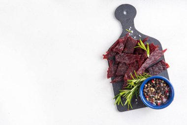 Kurutulmuş et, kurutulmuş et. Sağlıklı et atıştırmalıkları, servis panosunda sos ve baharatlar, kopyalama alanı.