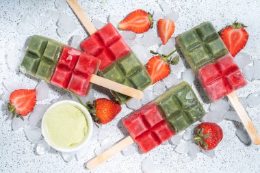 Sütsüz yeşil kibrit ve çilekli dondurma. Yeşil kibrit çay tozu ve dut suyu ile vejetaryen dondurması, beyaz beton arka planda sağlıklı organik tatlı.