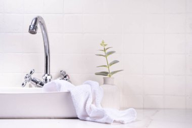 Lavabo, musluk ve tekstil bezi olan banyo arka planı. Beyaz basit, basit, boş banyo arkaplanı, ürünleriniz ya da metinleriniz için modelleyin