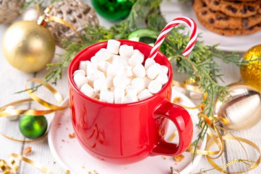 Sıcak çikolatalı şenlikli kırmızı kupa ya da marşmelovlu latte, Noel sabahı için, Noel arkaplanda sıcak sıcak sıcak bir tatil içeceği.