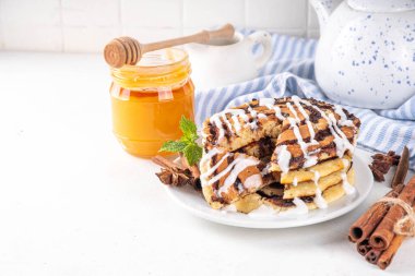 Ev yapımı tarçınlı krep yığını, tarçınlı krep sarmalı tarçın ve krem peynirli jöle, beyaz mutfak masası, fotokopi masası.