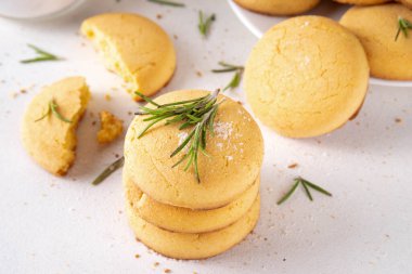 Baharatlı biberiye ve limonlu kurabiye. Tuzlu peynirli kurabiye aperatifleri ve beyaz mutfak masasında yemek pişirmek için gerekli malzemeler.