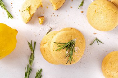 Baharatlı biberiye ve limonlu kurabiye. Tuzlu peynirli kurabiye aperatifleri ve beyaz mutfak masasında yemek pişirmek için gerekli malzemeler.