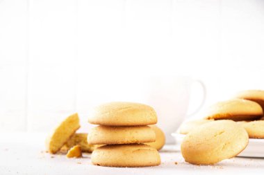 Ev yapımı kurabiyeler, geleneksel İngiliz çay partisi tereyağlı kurabiyeler, beyaz mutfak masasında tatlı kurabiyeler.