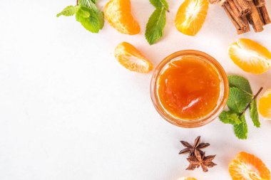 Baharatlı ve naneli ev yapımı altın tatlısı mandalina reçeli. Tatlı portakallı klementin reçeli ya da reçel reçeli kavanozda reçel reçeli ve arkaplanda dilimlenmiş mandalina