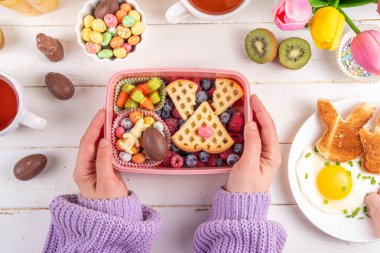 Sevimli Paskalya tarzı beslenme çantası. Yaratıcı çocuklar Paskalya sembolleri ve şekerlerle okul beslenme çantası - Tavşan tavşanı Belçika waffle sandviçleri, böğürtlen meyvesi, havuç şekeri, çikolata yumurtası