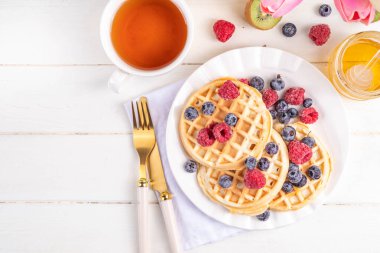 Beyaz ahşap masadaki böğürtlenli ev yapımı Belçika waffle 'ları lezzetli brunch' lar ya da Belçika waffle 'ları.