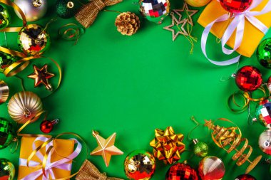 Parlak yeşil yeni yıl arkaplanı, kırmızı, yeşil, altın kostüm topları, flamalar ve süslemeler, üst görünüm fotokopi alanı. Noel ve Yeni Yıl tebrik kartı düzleştirildi