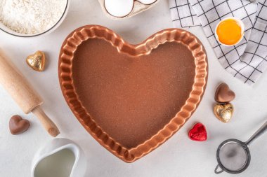 Tatlı Sevgililer Günü pastacılık geçmişi. Sevgililer günü kurabiyeleri, pastalar, çikolatalı tatlı, şeker parçacıkları, pişirme malzemeleri, un, yumurta, süt, yuvarlanan iğne üst görünümü. 