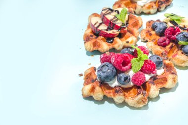 Modern tatlı mahsulü - kruvasan ve waffle karışımı, kabarık waffle ızgarası, böğürtlenli, meyveli çikolata soslu 