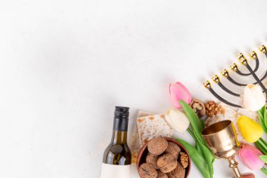 Hamursuz Bayramı geçmişi. Geleneksel Yahudi ekmek matzası, kırmızı koşer şarabı, ceviz, bahar güzel çiçekleri. Yahudi Paskalya Pesah bahar tatili arka plan kopya alanı