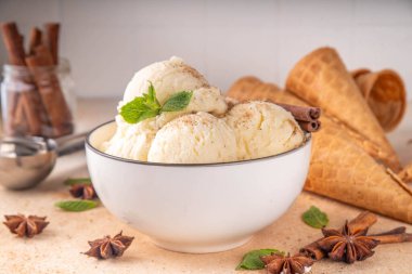 Hindistan 'da soğuk yaz Garam Masala Gelato tatlısı, Hindistan' da üç baharatlı dondurma, beyaz seramik kasede, nane yaprakları, baharatlar ve kremalı dondurma külahları.