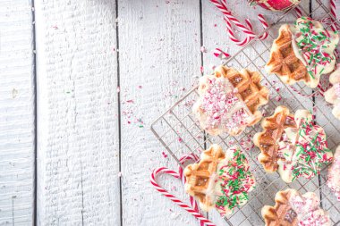 Noel kahvaltısı için bir yığın ev yapımı Belçika waffle 'ı. Geleneksel waffle 'lar beyaz çikolataya batırılmış, içinde şeker kırıntıları ve şeker parçacıkları var.