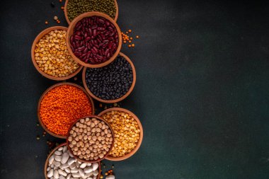 Çeşitli kuru fasulyeler, mercimek, mung, nohut, ahşap kaselerde bezelye çeşitleri. Legumes beyaz masa üst görünümünde. Vegan protein kaynakları yiyecek, kopyalama alanı