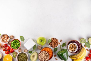 Portföy diyeti, fındık, sebze proteini, bitki sterolleri, yapışkan lif, fasulye, baklagiller, taze sebzeler ve beyaz arka plandaki meyveler dahil olmak üzere dengeli kolesterol vejetaryen gıdalar.