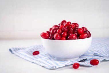 Cornelian kirazı, dogwoods yenilebilir dut mutfak masasının üzerinde beyaz kase içinde fotokopi alanı