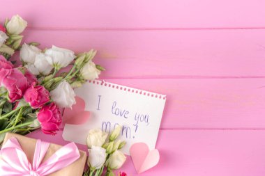 Anneler Günü uluslararası bayram tebrik kartı, gül buketi, şirin kartpostal notları kalp şeklinde sonsuza dek en iyi anne, pembe pastel arka planda düz bir şekilde yatıyordu.