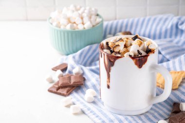 Marshmallow, graham kraker ve çikolatalı sütlü kahve, sıcak çikolata ya da latte bardağı.